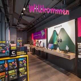 Moderner Mobilfunkladen mit iPhone 13 Werbung, Congstar Tarifen und Smartphone-Zubehör.