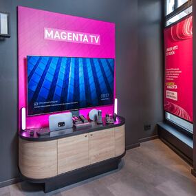 Modernes MagentaTV-Display mit Fernseher, smarten Geräten und Zubehör in hellem Showroom.